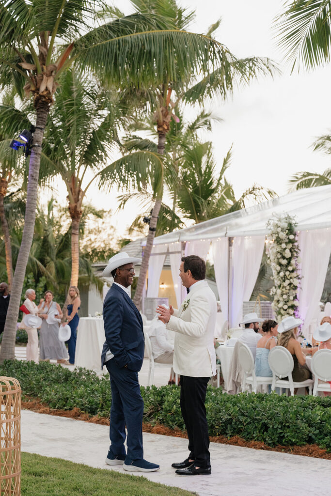 Ethereal white wedding reception with a breathtaking canopy of cascading white wisteria & green vines. Tables feature low, lush centerpieces combining garden roses, hydrangeas, spray roses, waxflower, delphinium, ranunculus, tulips, oncidium orchids, lisianthus, tweedia, lilac, sweet peas and are accented by deep-green foliage. This stunning floral design creates a luxurious, romantic, all-white atmosphere. Design by Rosemary & Finch Floral Design in Nashville, TN. 