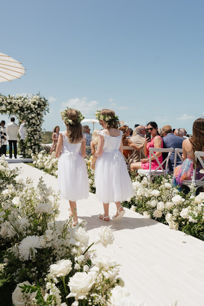 Lush, editorial bridal bouquet featuring all-white garden roses, ranunculus, delphinium, waxflower, oncidium, lisianthus, jasmine, sweet peas, tulips, clematis and a small mix of greenery. A slight hue of butter yellow is featured as well. Soft and romantic bouquet to highlight the airiness of a beachfront wedding in the Bahamas. Design by Rosemary & Finch Floral Design in Nashville, TN. 