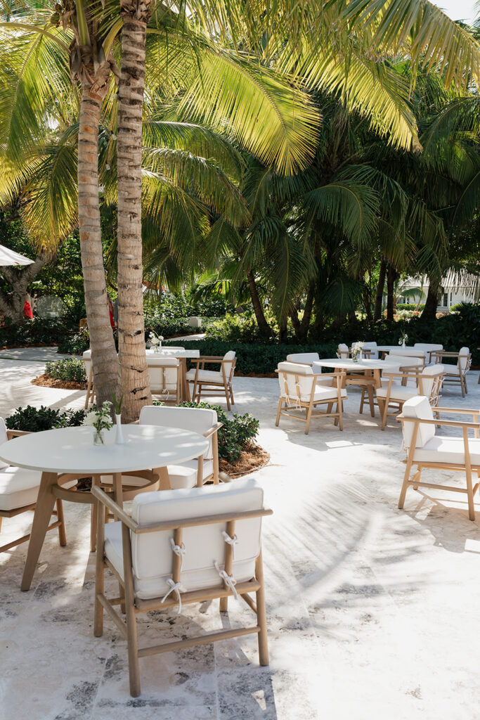 Simple, romantic all white floral bud vase arrangements for stunning bahamas cocktail hour. Bud vases are accompanied by all-white statement piece arrangements featuring garden roses, hydrangeas, spray roses, waxflower, delphinium, ranunculus, tulips, oncidium orchids, lisianthus, tweedia, lilac, sweet peas and are accented by a mix of greenery. Design by Rosemary & Finch Floral Design in Nashville, TN. 
