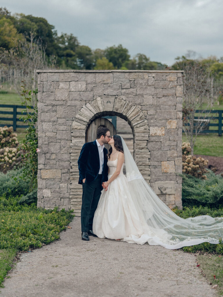 An autumnal, simple bridal bouquet displaying colors of burgundy, blush, rusty orange, and peach. Stunning florals include dahlias, garden roses, moab roses, cappuccino roses, brown ranunculus, zinnias, chocolate cosmos, brown sweet peas, toffee lisianthus, yarrow, marigolds and amaranthus. Beautiful fall florals for a wedding at Southall, TN. Design by Rosemary and Finch Floral Design in Nashville, TN.