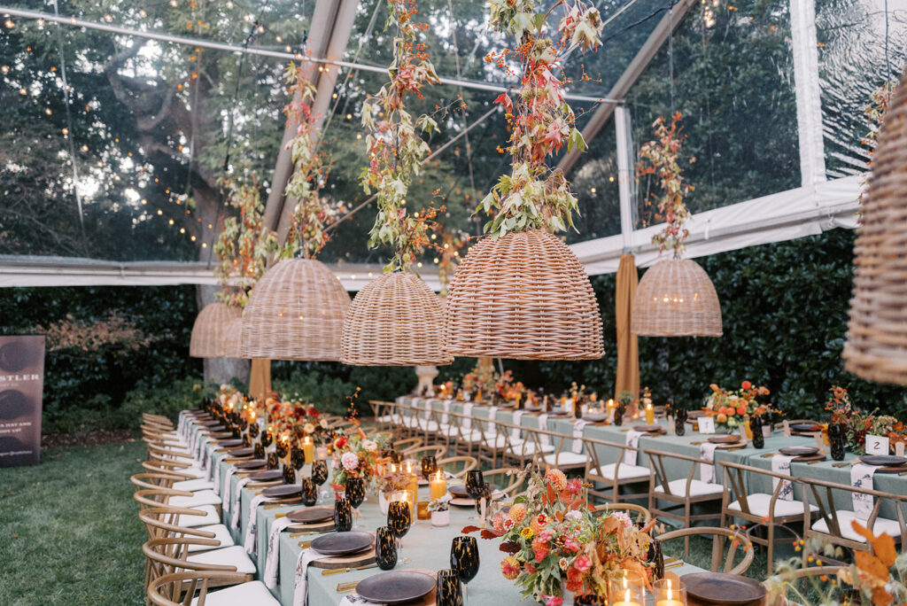 Gorgeous, flower-forward centerpiece arrangements for a private birthday party in Nashville, TN. Autumnal hues of red, brown, orange, pinks and cream are showcased in a stunning display of dahlias, zinnias, ranunculus, nigella, viburnum, rudbeckia, marigolds, liquid amber, spray roses, geranium, rose hips and bittersweet. Fall foliage provides greenery for arrangements and are wrapped around each tent pole and pendant. Design by Rosemary and Finch Floral Design in Nashville, TN. 
