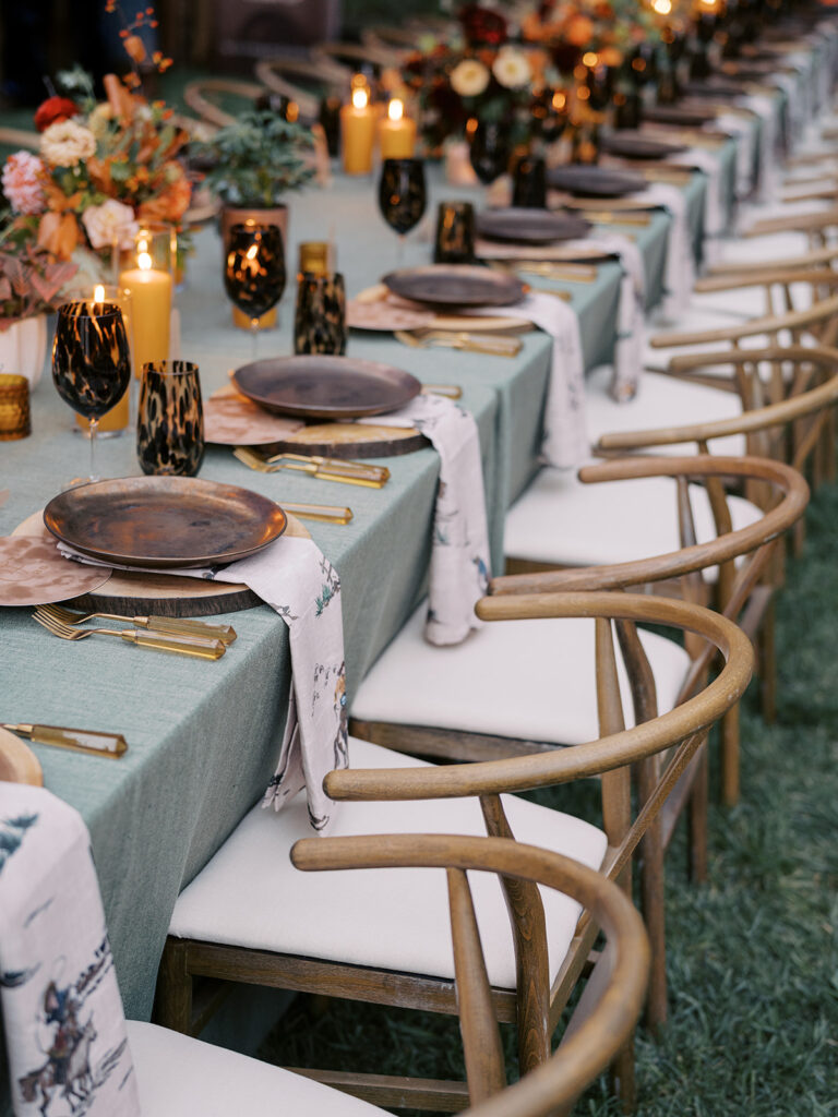 Gorgeous, flower-forward centerpiece arrangements for a private birthday party in Nashville, TN. Autumnal hues of red, brown, orange, pinks and cream are showcased in a stunning display of dahlias, zinnias, ranunculus, nigella, viburnum, rudbeckia, marigolds, liquid amber, spray roses, geranium, rose hips and bittersweet. Fall foliage provides greenery for arrangements and are wrapped around each tent pole and pendant. Design by Rosemary and Finch Floral Design in Nashville, TN. 
