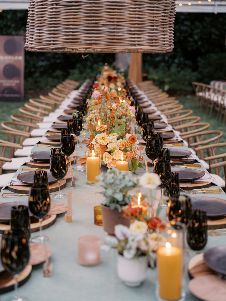 Gorgeous, flower-forward centerpiece arrangements for a private birthday party in Nashville, TN. Autumnal hues of red, brown, orange, pinks and cream are showcased in a stunning display of dahlias, zinnias, ranunculus, nigella, viburnum, rudbeckia, marigolds, liquid amber, spray roses, geranium, rose hips and bittersweet. Fall foliage provides greenery for arrangements and are wrapped around each tent pole and pendant. Design by Rosemary and Finch Floral Design in Nashville, TN. 