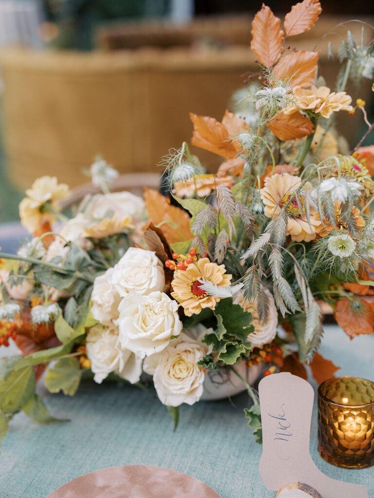 Gorgeous, flower-forward centerpiece arrangements for a private birthday party in Nashville, TN. Autumnal hues of red, brown, orange, pinks and cream are showcased in a stunning display of dahlias, zinnias, ranunculus, nigella, viburnum, rudbeckia, marigolds, liquid amber, spray roses, geranium, rose hips and bittersweet. Fall foliage provides greenery for arrangements and are wrapped around each tent pole and pendant. Design by Rosemary and Finch Floral Design in Nashville, TN. 