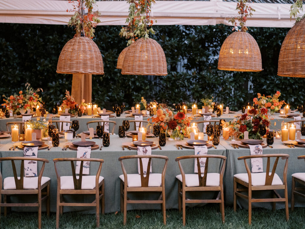 Gorgeous, flower-forward centerpiece arrangements for a private birthday party in Nashville, TN. Autumnal hues of red, brown, orange, pinks and cream are showcased in a stunning display of dahlias, zinnias, ranunculus, nigella, viburnum, rudbeckia, marigolds, liquid amber, spray roses, geranium, rose hips and bittersweet. Fall foliage provides greenery for arrangements and are wrapped around each tent pole and pendant. Design by Rosemary and Finch Floral Design in Nashville, TN. 