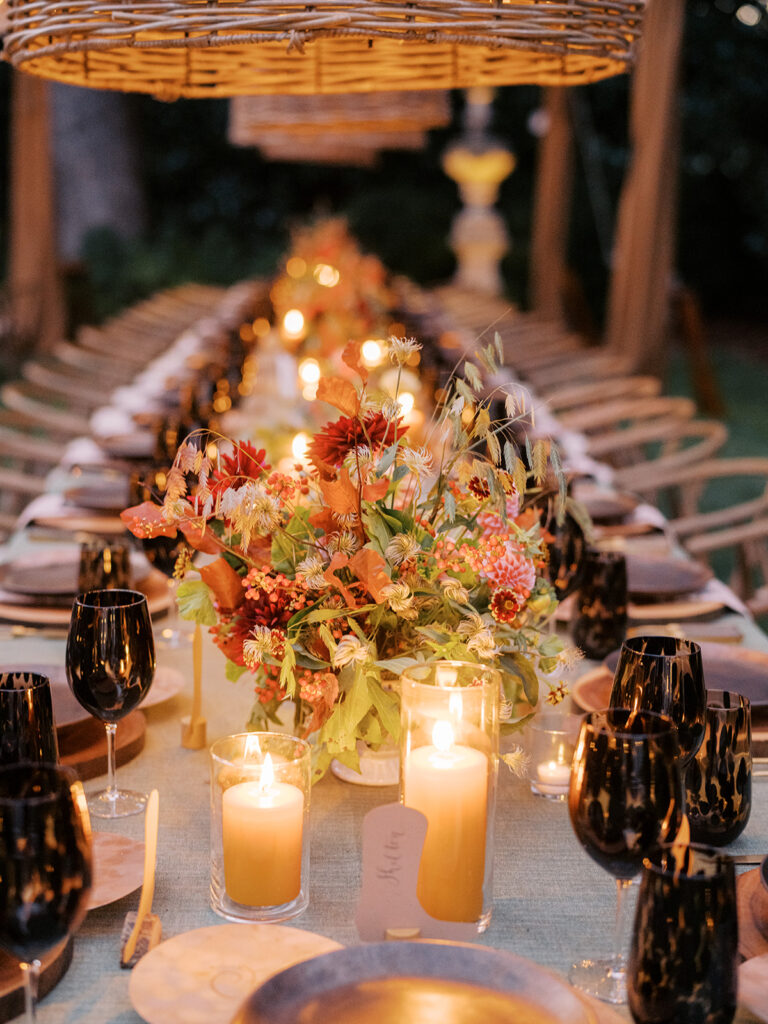 Gorgeous, flower-forward centerpiece arrangements for a private birthday party in Nashville, TN. Autumnal hues of red, brown, orange, pinks and cream are showcased in a stunning display of dahlias, zinnias, ranunculus, nigella, viburnum, rudbeckia, marigolds, liquid amber, spray roses, geranium, rose hips and bittersweet. Fall foliage provides greenery for arrangements and are wrapped around each tent pole and pendant. Design by Rosemary and Finch Floral Design in Nashville, TN. 