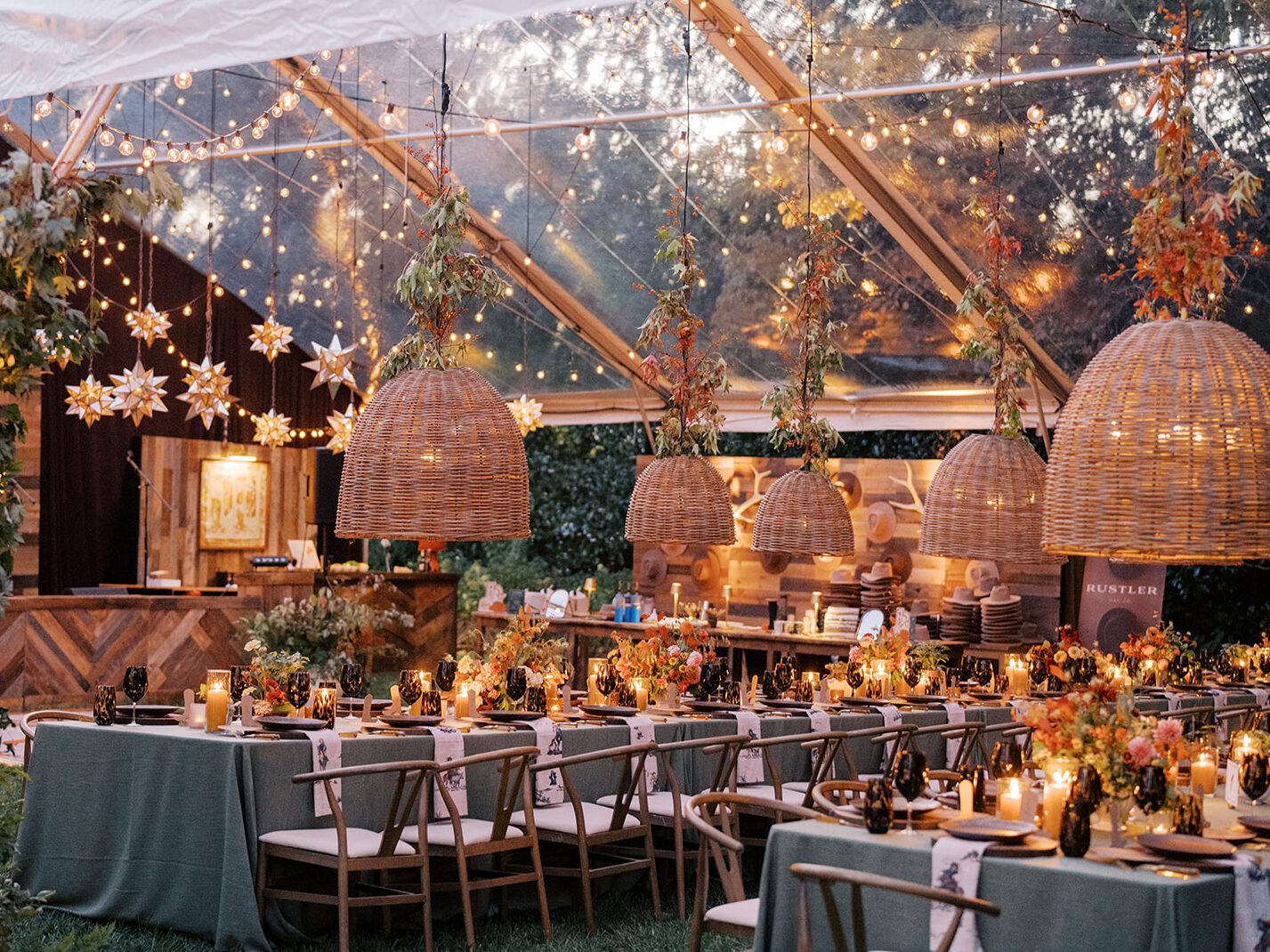 Gorgeous, flower-forward centerpiece arrangements for a private birthday party in Nashville, TN. Autumnal hues of red, brown, orange, pinks and cream are showcased in a stunning display of dahlias, zinnias, ranunculus, nigella, viburnum, rudbeckia, marigolds, liquid amber, spray roses, geranium, rose hips and bittersweet. Fall foliage provides greenery for arrangements and are wrapped around each tent pole and pendant. Design by Rosemary and Finch Floral Design in Nashville, TN. 
