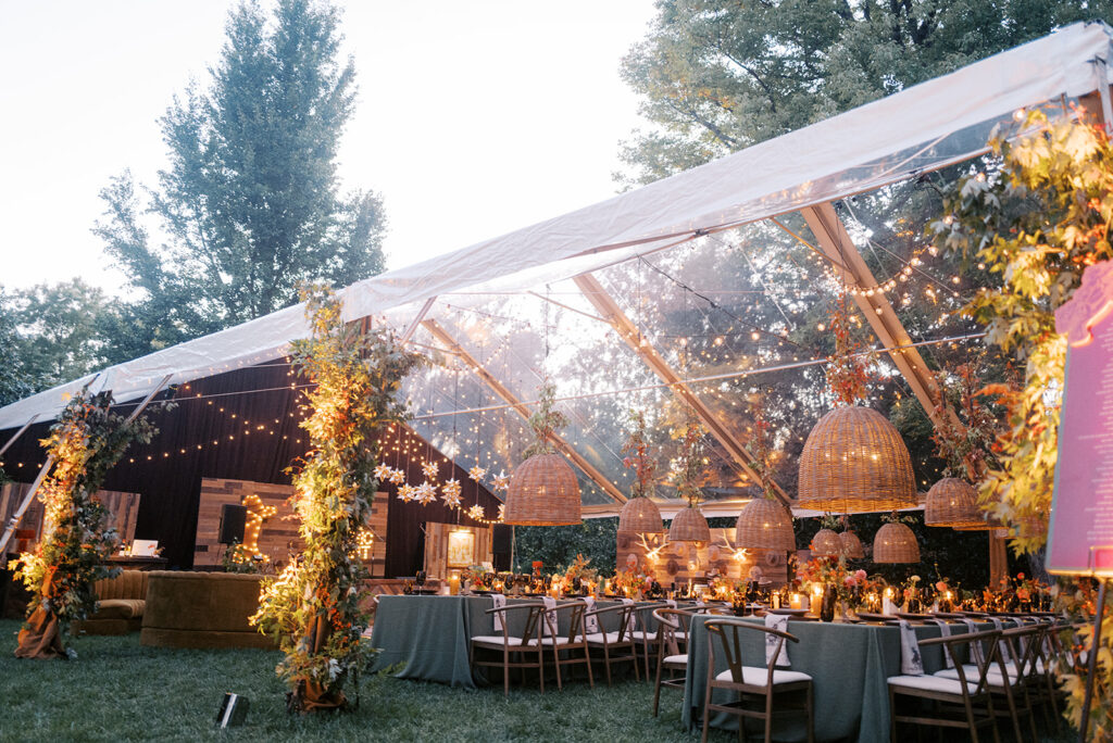 Gorgeous, flower-forward centerpiece arrangements for a private birthday party in Nashville, TN. Autumnal hues of red, brown, orange, pinks and cream are showcased in a stunning display of dahlias, zinnias, ranunculus, nigella, viburnum, rudbeckia, marigolds, liquid amber, spray roses, geranium, rose hips and bittersweet. Fall foliage provides greenery for arrangements and are wrapped around each tent pole and pendant. Design by Rosemary and Finch Floral Design in Nashville, TN. 