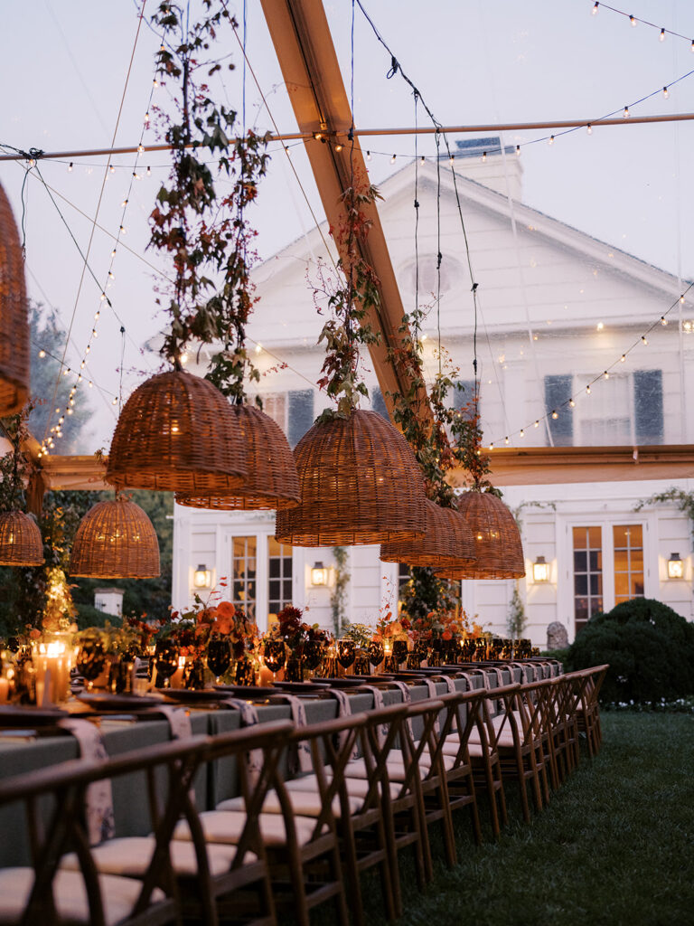 Gorgeous, flower-forward centerpiece arrangements for a private birthday party in Nashville, TN. Autumnal hues of red, brown, orange, pinks and cream are showcased in a stunning display of dahlias, zinnias, ranunculus, nigella, viburnum, rudbeckia, marigolds, liquid amber, spray roses, geranium, rose hips and bittersweet. Fall foliage provides greenery for arrangements and are wrapped around each tent pole and pendant. Design by Rosemary and Finch Floral Design in Nashville, TN. 
