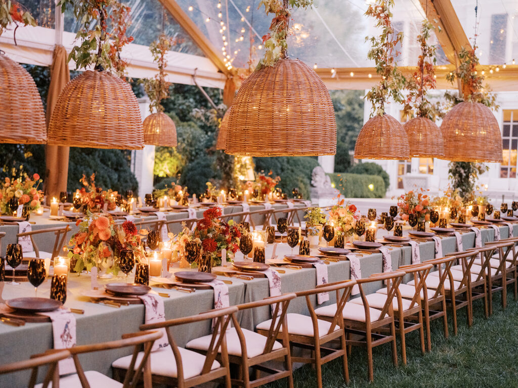 Gorgeous, flower-forward centerpiece arrangements for a private birthday party in Nashville, TN. Autumnal hues of red, brown, orange, pinks and cream are showcased in a stunning display of dahlias, zinnias, ranunculus, nigella, viburnum, rudbeckia, marigolds, liquid amber, spray roses, geranium, rose hips and bittersweet. Fall foliage provides greenery for arrangements and are wrapped around each tent pole and pendant. Design by Rosemary and Finch Floral Design in Nashville, TN. 