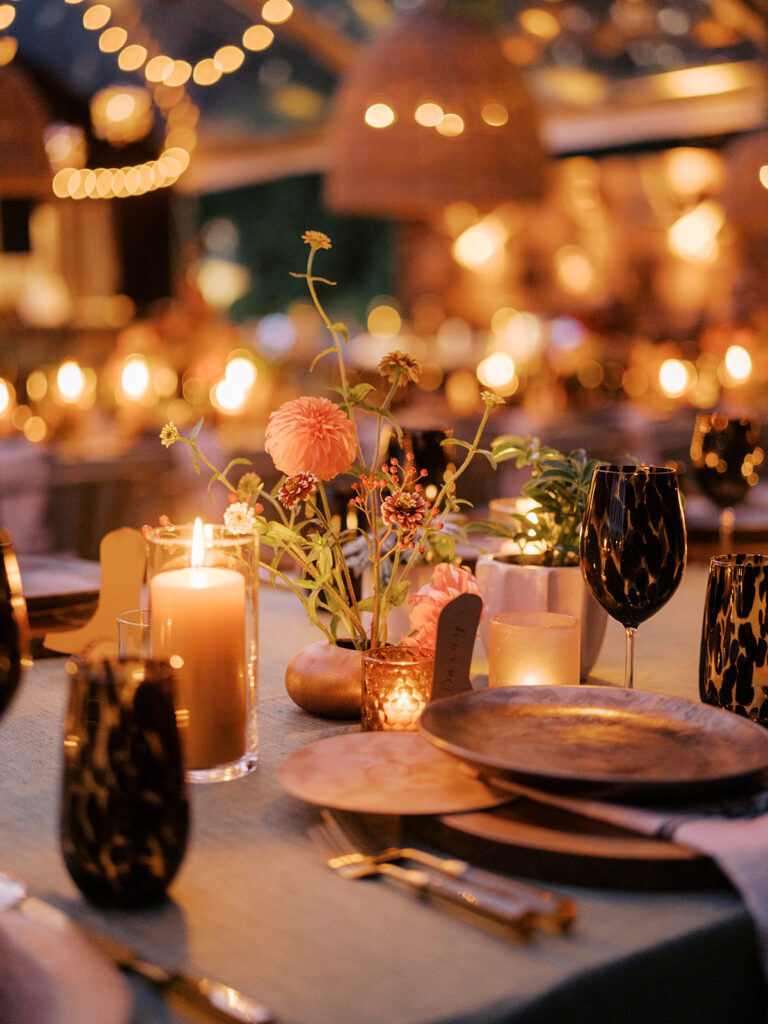 Stunning, autumnal ikebana centerpieces for a private birthday party in Nashville, TN. Each arrangement holds varying clusters of peach, burgundy and orange dahlias, spray roses, nigella, clematis pods, copper zinnias, red gem marigolds, salmon sweet peas, brown ranunculus, rose hips, explosion grass and lisianthus. Bright colors draw the eye to a beautiful table display surrounded by warm tea lights and woven pendants above. Design by Rosemary and Finch Floral Design in Nashville, TN. 