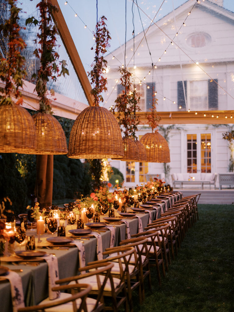 Gorgeous, flower-forward centerpiece arrangements for a private birthday party in Nashville, TN. Autumnal hues of red, brown, orange, pinks and cream are showcased in a stunning display of dahlias, zinnias, ranunculus, nigella, viburnum, rudbeckia, marigolds, liquid amber, spray roses, geranium, rose hips and bittersweet. Fall foliage provides greenery for arrangements and are wrapped around each tent pole and pendant. Design by Rosemary and Finch Floral Design in Nashville, TN. 
