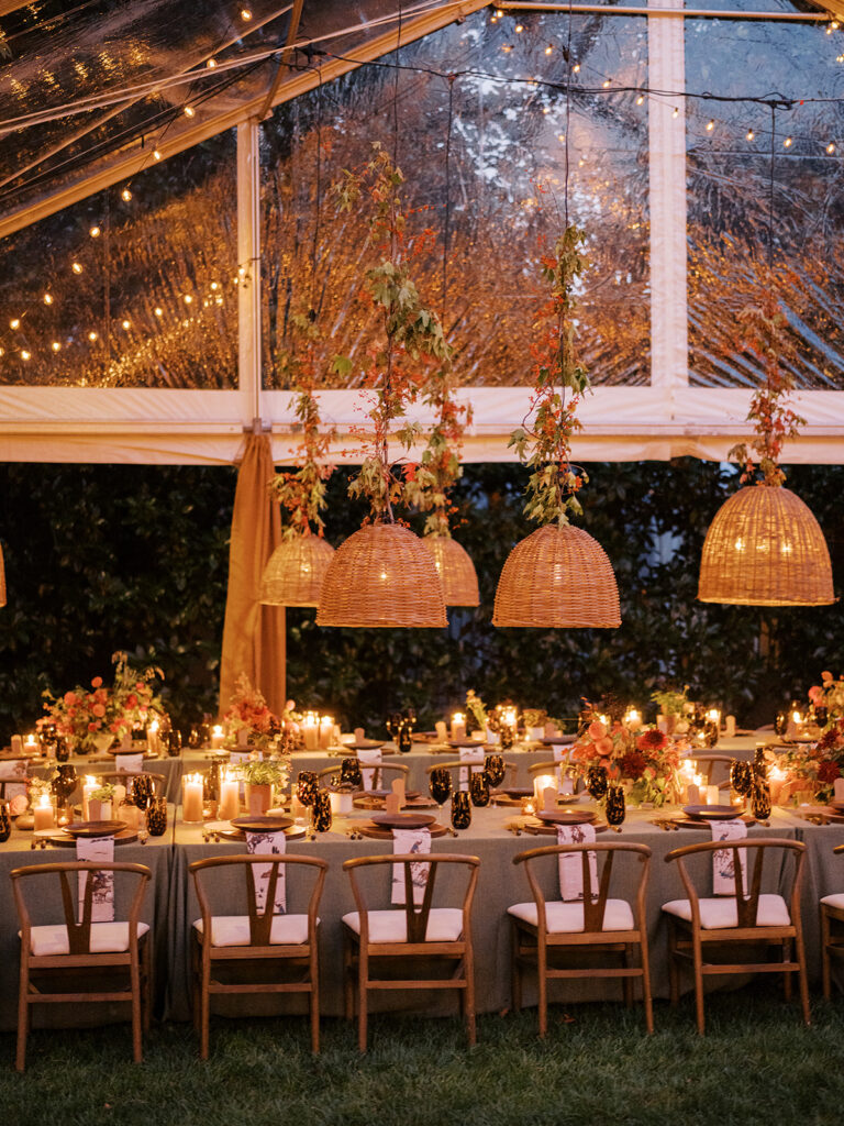 Gorgeous, flower-forward centerpiece arrangements for a private birthday party in Nashville, TN. Autumnal hues of red, brown, orange, pinks and cream are showcased in a stunning display of dahlias, zinnias, ranunculus, nigella, viburnum, rudbeckia, marigolds, liquid amber, spray roses, geranium, rose hips and bittersweet. Fall foliage provides greenery for arrangements and are wrapped around each tent pole and pendant. Design by Rosemary and Finch Floral Design in Nashville, TN. 