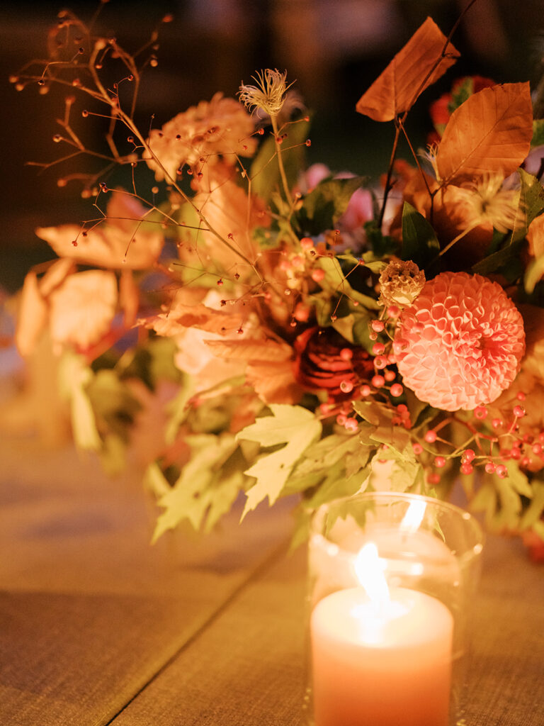 Gorgeous, flower-forward centerpiece arrangements for a private birthday party in Nashville, TN. Autumnal hues of red, brown, orange, pinks and cream are showcased in a stunning display of dahlias, zinnias, ranunculus, nigella, viburnum, rudbeckia, marigolds, liquid amber, spray roses, geranium, rose hips and bittersweet. Fall foliage provides greenery for arrangements and are wrapped around each tent pole and pendant. Design by Rosemary and Finch Floral Design in Nashville, TN. 