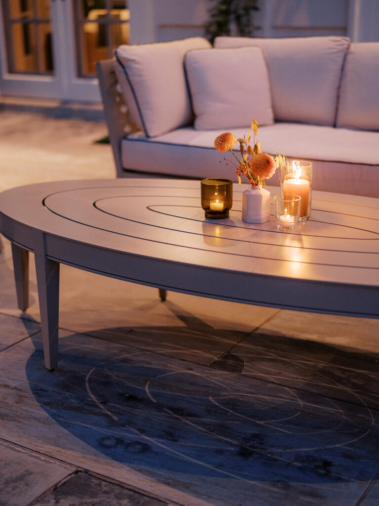 White ceramic bud vases with light florals scattered throughout cocktail hour for a private birthday party event in Nashville, TN. Bud vases consist of light greenery, peach dahlias, explosion grass, amber ranunculus, toffee lisianthus, copper zinnias, red marigolds, clematis pods, and nigella. Design by Rosemary and Finch Floral Design in Nashville, TN. 