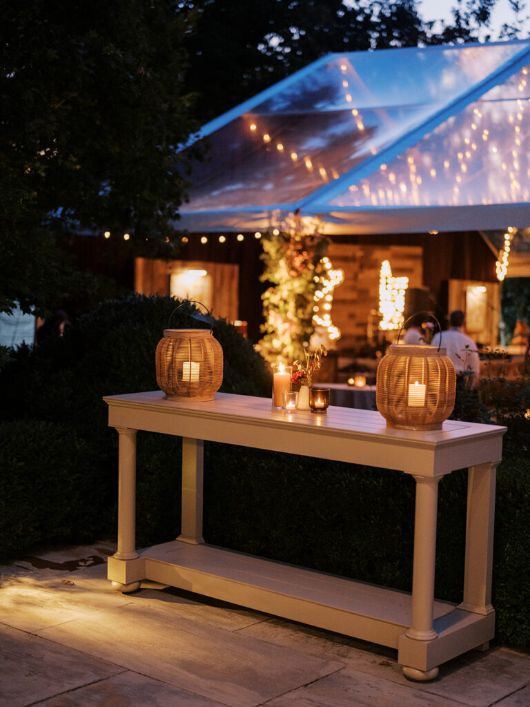 White ceramic bud vases with light florals scattered throughout cocktail hour for a private birthday party event in Nashville, TN. Bud vases consist of light greenery, peach dahlias, explosion grass, amber ranunculus, toffee lisianthus, copper zinnias, red marigolds, clematis pods, and nigella. Design by Rosemary and Finch Floral Design in Nashville, TN. 