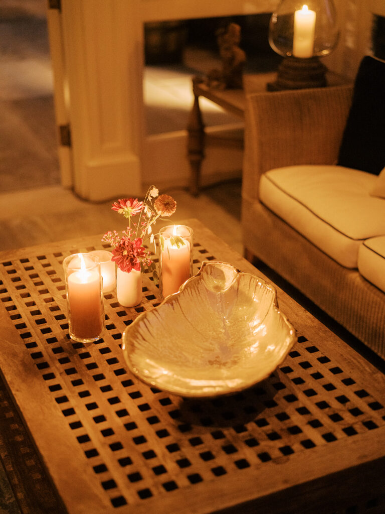 White ceramic bud vases with light florals scattered throughout cocktail hour for a private birthday party event in Nashville, TN. Bud vases consist of light greenery, peach dahlias, explosion grass, amber ranunculus, toffee lisianthus, copper zinnias, red marigolds, clematis pods, and nigella. Design by Rosemary and Finch Floral Design in Nashville, TN. 