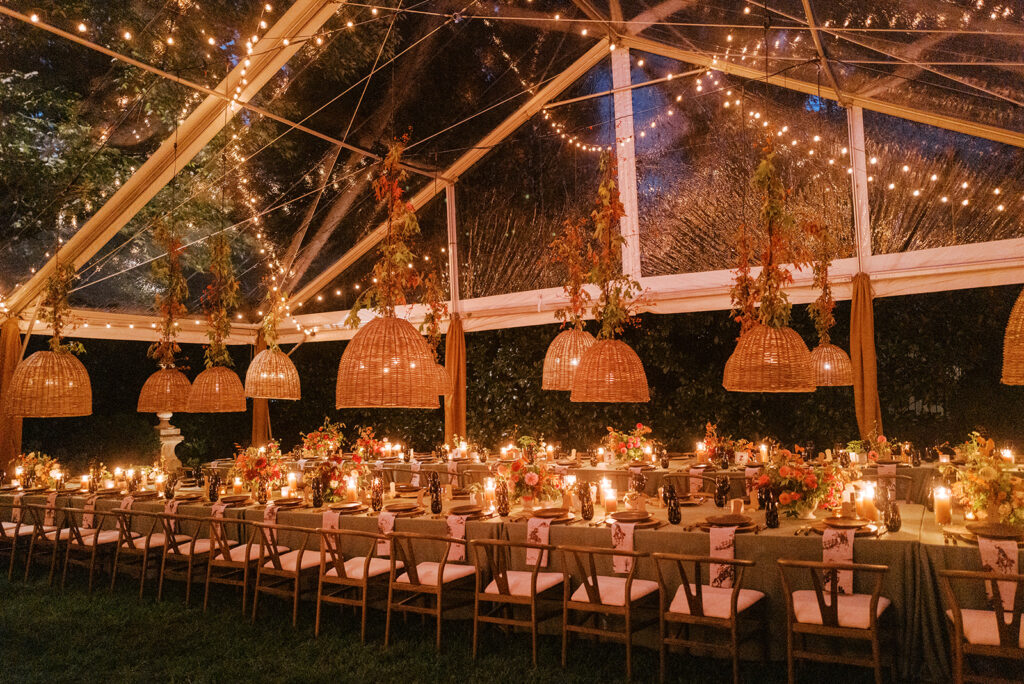 Gorgeous, flower-forward centerpiece arrangements for a private birthday party in Nashville, TN. Autumnal hues of red, brown, orange, pinks and cream are showcased in a stunning display of dahlias, zinnias, ranunculus, nigella, viburnum, rudbeckia, marigolds, liquid amber, spray roses, geranium, rose hips and bittersweet. Fall foliage provides greenery for arrangements and are wrapped around each tent pole and pendant. Design by Rosemary and Finch Floral Design in Nashville, TN. 