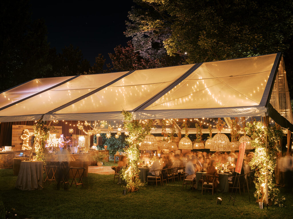 Gorgeous, flower-forward centerpiece arrangements for a private birthday party in Nashville, TN. Autumnal hues of red, brown, orange, pinks and cream are showcased in a stunning display of dahlias, zinnias, ranunculus, nigella, viburnum, rudbeckia, marigolds, liquid amber, spray roses, geranium, rose hips and bittersweet. Fall foliage provides greenery for arrangements and are wrapped around each tent pole and pendant. Design by Rosemary and Finch Floral Design in Nashville, TN. 
