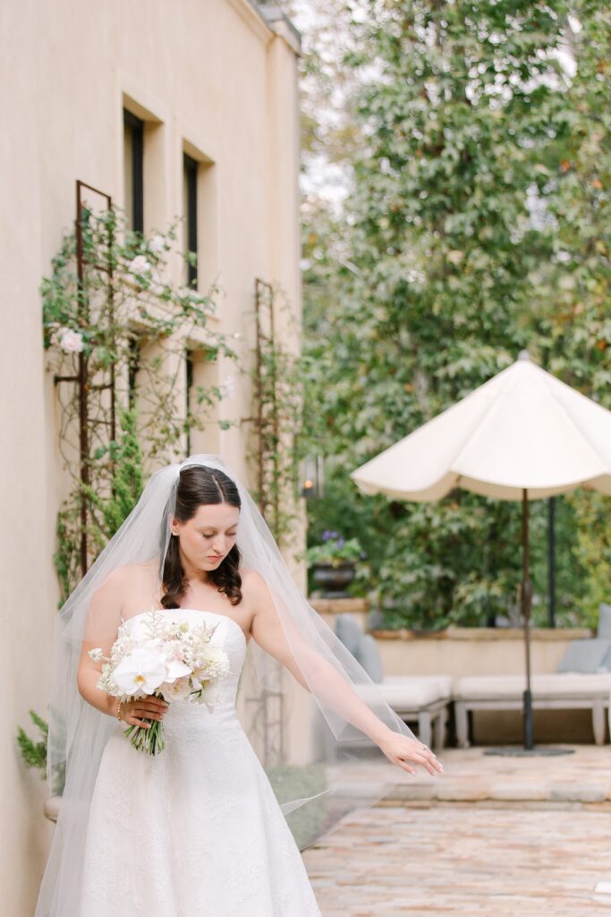 Stunning, elegant flower-forward all-white bridal bouquet with hints of blush and pink for Belle Meade wedding in Nashville. Florals highlighted are phalaenopsis, dahlias, garden roses, majolika roses, ranunculus, butterfly ranunculus, clematis, sweet peas, astilbe, scabiosa and light greenery. The white phalaenopsis creates a soft and bright focal moment for the bouquet. Design by Rosemary and Finch Floral Design in Nashville, TN. 