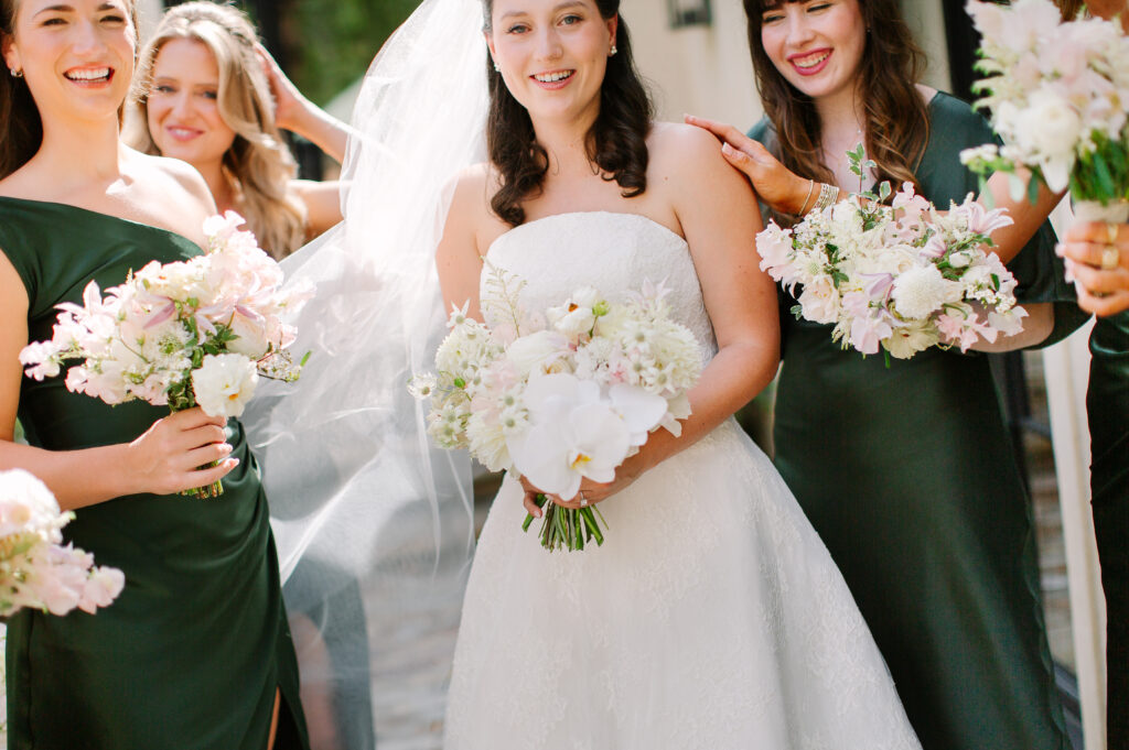 Stunning, elegant flower-forward all-white bridal bouquet with hints of blush and pink for Belle Meade wedding in Nashville. Florals highlighted are phalaenopsis, dahlias, garden roses, majolika roses, ranunculus, butterfly ranunculus, clematis, sweet peas, astilbe, scabiosa and light greenery. The white phalaenopsis creates a soft and bright focal moment for the bouquet. Design by Rosemary and Finch Floral Design in Nashville, TN. 