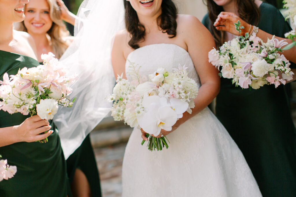 Stunning, elegant flower-forward all-white bridal bouquet with hints of blush and pink for Belle Meade wedding in Nashville. Florals highlighted are phalaenopsis, dahlias, garden roses, majolika roses, ranunculus, butterfly ranunculus, clematis, sweet peas, astilbe, scabiosa and light greenery. The white phalaenopsis creates a soft and bright focal moment for the bouquet. Design by Rosemary and Finch Floral Design in Nashville, TN. 