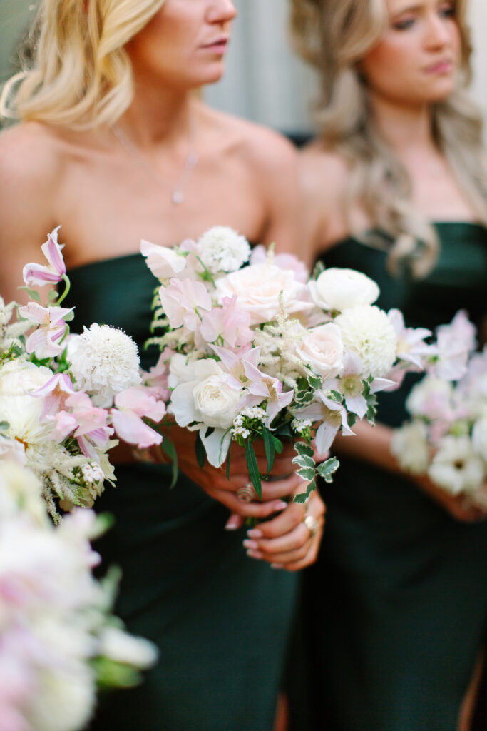 Simple and elegant all-white bridesmaid bouquets with hints of blush and pink for Belle Meade wedding in Nashville. Florals highlighted are dahlias, garden roses, majolika roses, ranunculus, butterfly ranunculus, clematis, sweet peas, astilbe, scabiosa, pieris, saponaria and minimal greenery. The white phalaenopsis creates a soft and bright focal moment for the bouquet. Design by Rosemary and Finch Floral Design in Nashville, TN. 