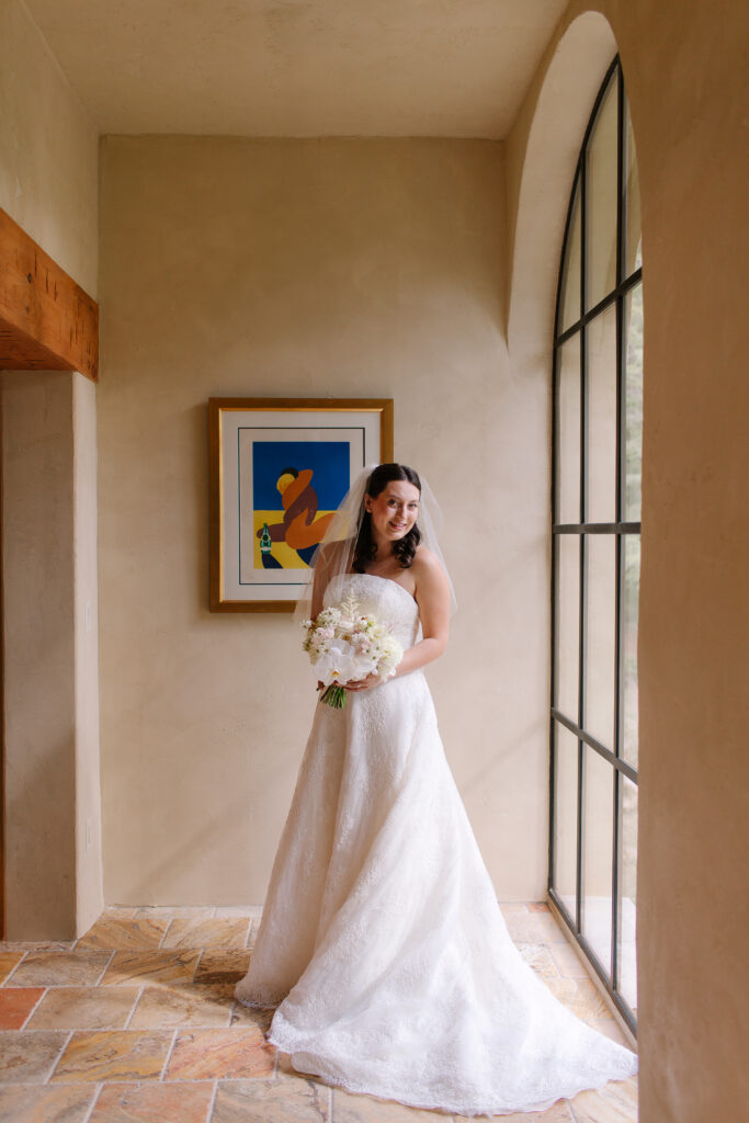 Stunning, elegant flower-forward all-white bridal bouquet with hints of blush and pink for Belle Meade wedding in Nashville. Florals highlighted are phalaenopsis, dahlias, garden roses, majolika roses, ranunculus, butterfly ranunculus, clematis, sweet peas, astilbe, scabiosa and light greenery. The white phalaenopsis creates a soft and bright focal moment for the bouquet. Design by Rosemary and Finch Floral Design in Nashville, TN. 