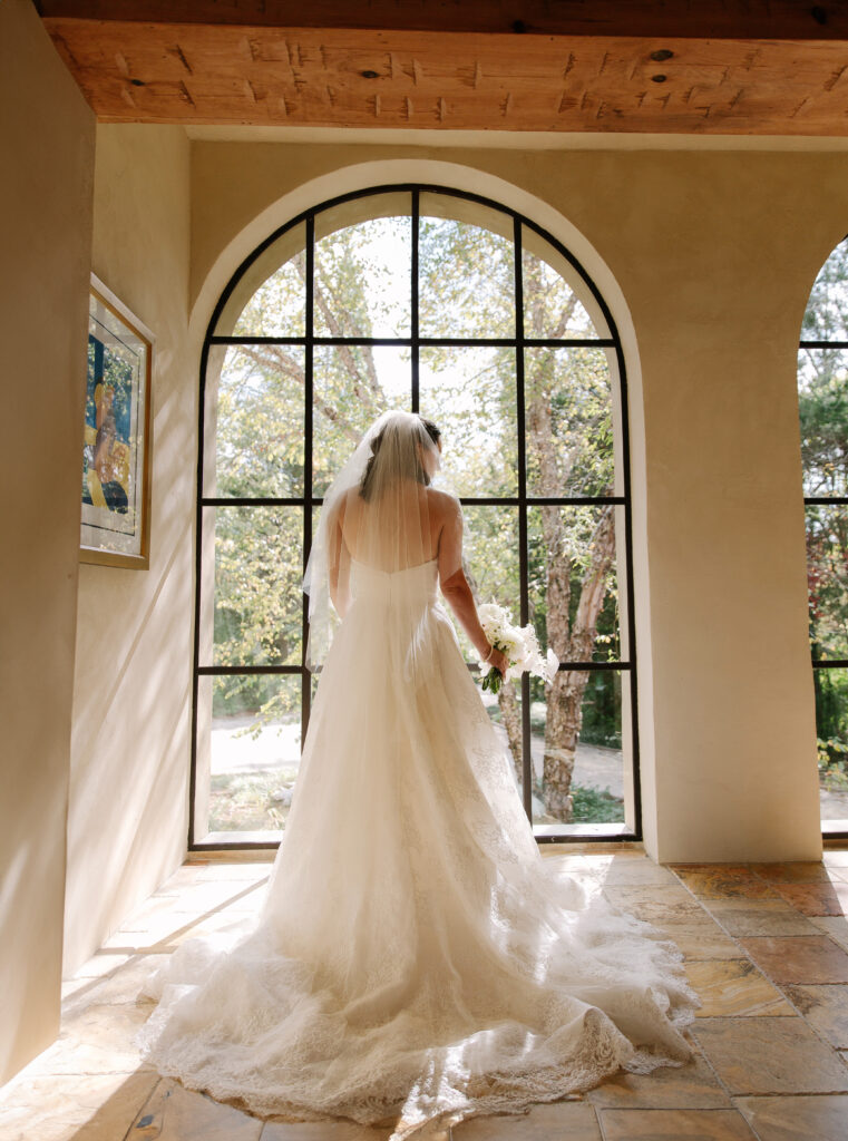 Stunning, elegant flower-forward all-white bridal bouquet with hints of blush and pink for Belle Meade wedding in Nashville. Florals highlighted are phalaenopsis, dahlias, garden roses, majolika roses, ranunculus, butterfly ranunculus, clematis, sweet peas, astilbe, scabiosa and light greenery. The white phalaenopsis creates a soft and bright focal moment for the bouquet. Design by Rosemary and Finch Floral Design in Nashville, TN. 