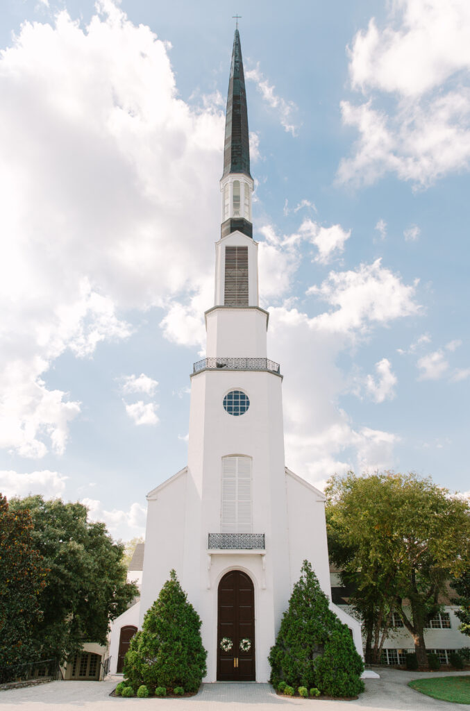 Wedding floral wreaths add a romantic, garden-inspired touch to private home and church doors for a wedding ceremony in Nashville. Designed with white florals and simple greenery, these handcrafted wreaths feature playa blanca roses, quicksand roses, champagne roses, majolikas,  and pieris, creating an elegant and timeless wedding floral statement. Design by Rosemary and Finch Floral Design in Nashville, TN. 