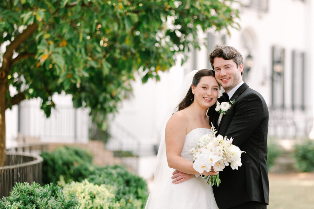 Stunning, elegant flower-forward all-white bridal bouquet with hints of blush and pink for Belle Meade wedding in Nashville. Florals highlighted are phalaenopsis, dahlias, garden roses, majolika roses, ranunculus, butterfly ranunculus, clematis, sweet peas, astilbe, scabiosa and light greenery. The white phalaenopsis creates a soft and bright focal moment for the bouquet. Design by Rosemary and Finch Floral Design in Nashville, TN. 