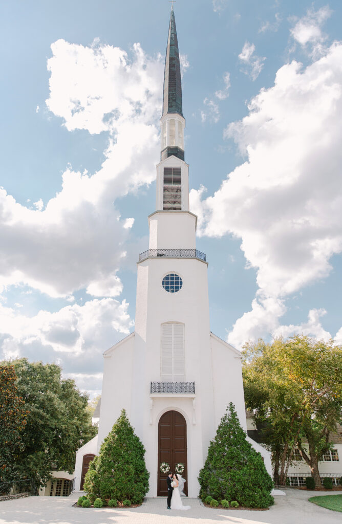 Wedding floral wreaths add a romantic, garden-inspired touch to private home and church doors for a wedding ceremony in Nashville. Designed with white florals and simple greenery, these handcrafted wreaths feature playa blanca roses, quicksand roses, champagne roses, majolikas,  and pieris, creating an elegant and timeless wedding floral statement. Design by Rosemary and Finch Floral Design in Nashville, TN. 