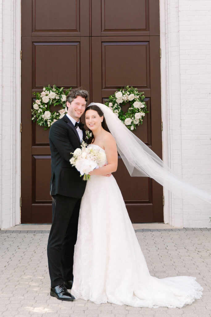 Stunning, elegant flower-forward all-white bridal bouquet with hints of blush and pink for Belle Meade wedding in Nashville. Florals highlighted are phalaenopsis, dahlias, garden roses, majolika roses, ranunculus, butterfly ranunculus, clematis, sweet peas, astilbe, scabiosa and light greenery. The white phalaenopsis creates a soft and bright focal moment for the bouquet. Design by Rosemary and Finch Floral Design in Nashville, TN. 