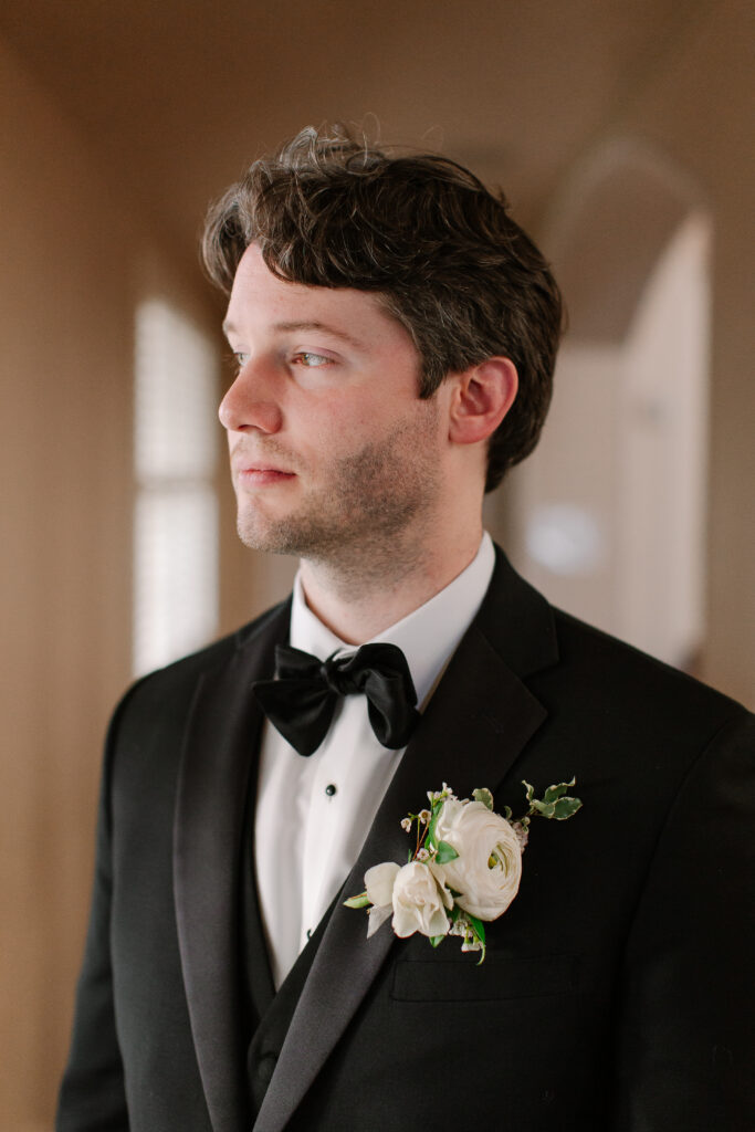 Simple boutonnieres consisting of all white majolikas, ranunculus, pieris and light greenery. Design by Rosemary and Finch Floral Design in Nashville, TN. 