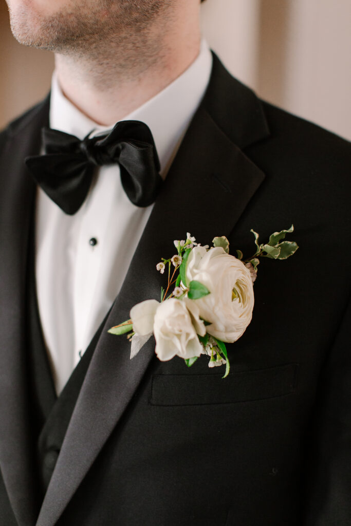 Simple boutonnieres consisting of all white majolikas, ranunculus, pieris and light greenery. Design by Rosemary and Finch Floral Design in Nashville, TN. 