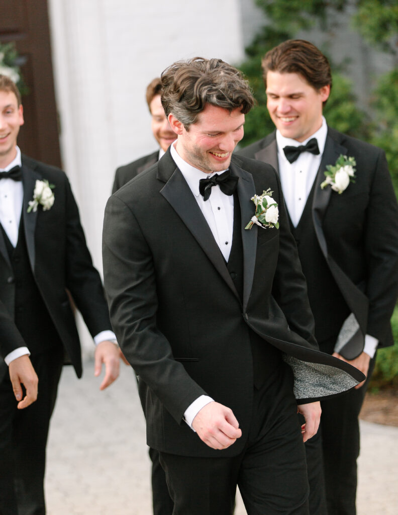 Simple boutonnieres consisting of all white majolikas, ranunculus, pieris and light greenery. Design by Rosemary and Finch Floral Design in Nashville, TN. 
