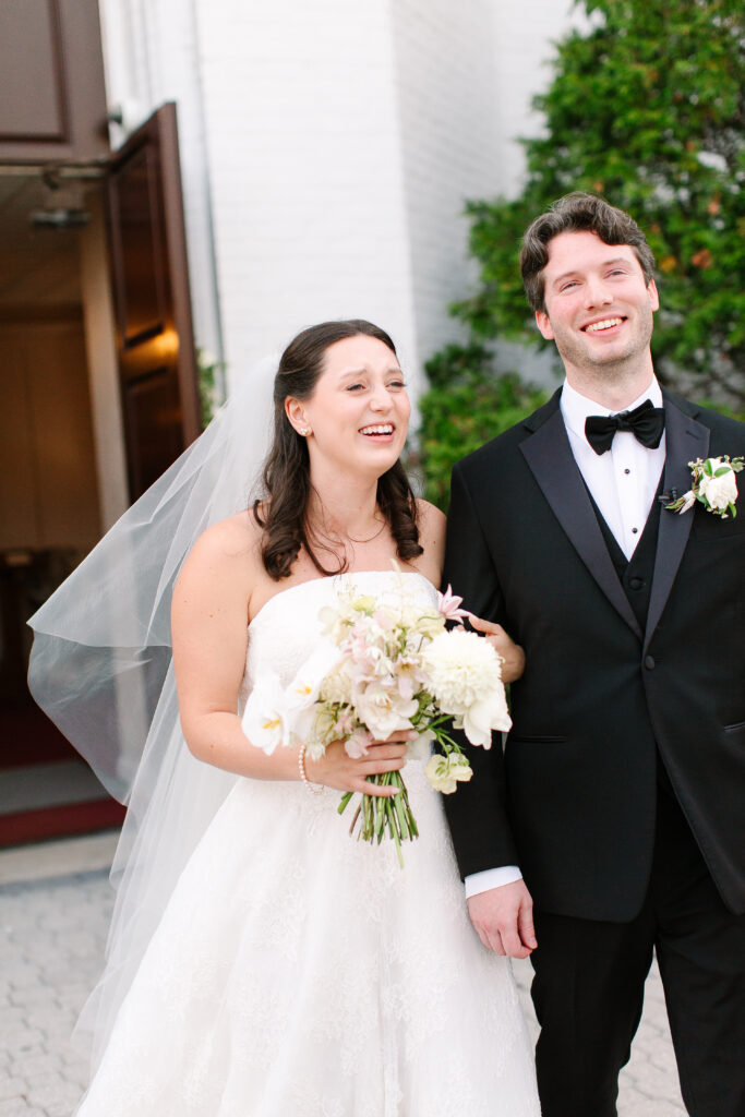 Stunning, elegant flower-forward all-white bridal bouquet with hints of blush and pink for Belle Meade wedding in Nashville. Florals highlighted are phalaenopsis, dahlias, garden roses, majolika roses, ranunculus, butterfly ranunculus, clematis, sweet peas, astilbe, scabiosa and light greenery. The white phalaenopsis creates a soft and bright focal moment for the bouquet. Design by Rosemary and Finch Floral Design in Nashville, TN. 