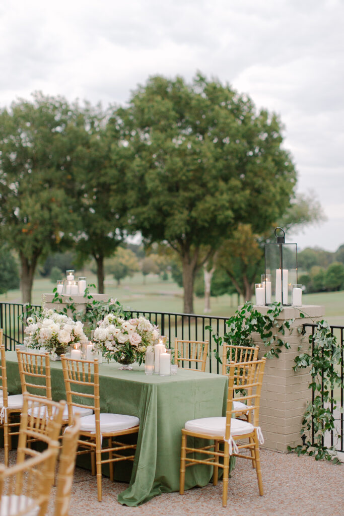 Lush and elegant floral centerpieces for Nashville wedding at Hillwood Country Club. Light pinks, blush and white florals consist of dahlias, garden roses, playa blancas, quicksand roses, ranunculus, lisianthus, majolikas, pieris, delphinium, sweet peas, saponaria, clematis, astilbe, and contrasting greenery. Centerpieces were accompanied by warm candlelight and lush vines growing near the bar for a beautiful wedding reception. Design by Rosemary and Finch Floral Design in Nashville, TN. 