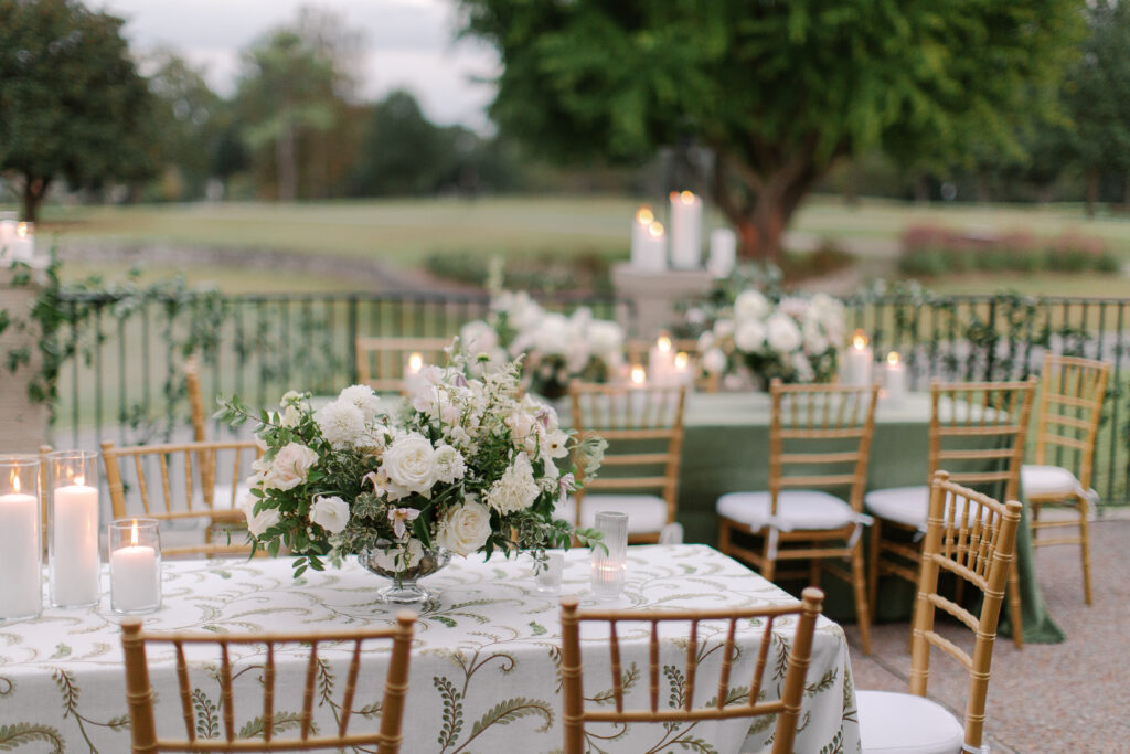 Lush and elegant floral centerpieces for Nashville wedding at Hillwood Country Club. Light pinks, blush and white florals consist of dahlias, garden roses, playa blancas, quicksand roses, ranunculus, lisianthus, majolikas, pieris, delphinium, sweet peas, saponaria, clematis, astilbe, and contrasting greenery. Centerpieces were accompanied by warm candlelight and lush vines growing near the bar for a beautiful wedding reception. Design by Rosemary and Finch Floral Design in Nashville, TN. 