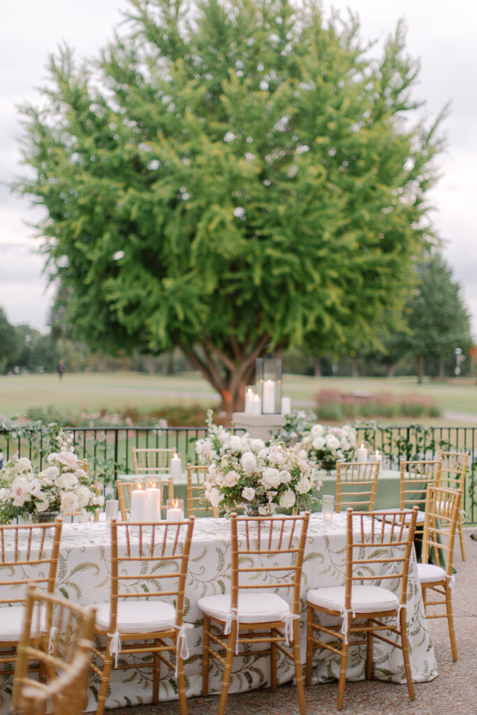 Lush and elegant floral centerpieces for Nashville wedding at Hillwood Country Club. Light pinks, blush and white florals consist of dahlias, garden roses, playa blancas, quicksand roses, ranunculus, lisianthus, majolikas, pieris, delphinium, sweet peas, saponaria, clematis, astilbe, and contrasting greenery. Centerpieces were accompanied by warm candlelight and lush vines growing near the bar for a beautiful wedding reception. Design by Rosemary and Finch Floral Design in Nashville, TN. 