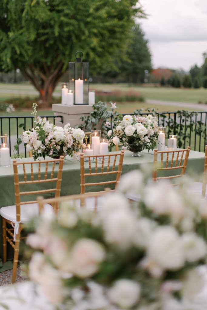 Lush and elegant floral centerpieces for Nashville wedding at Hillwood Country Club. Light pinks, blush and white florals consist of dahlias, garden roses, playa blancas, quicksand roses, ranunculus, lisianthus, majolikas, pieris, delphinium, sweet peas, saponaria, clematis, astilbe, and contrasting greenery. Centerpieces were accompanied by warm candlelight and lush vines growing near the bar for a beautiful wedding reception. Design by Rosemary and Finch Floral Design in Nashville, TN. 