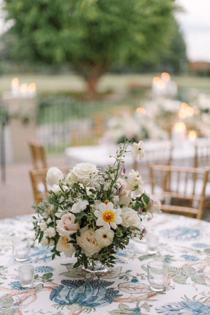 Lush and elegant floral centerpieces for Nashville wedding at Hillwood Country Club. Light pinks, blush and white florals consist of dahlias, garden roses, playa blancas, quicksand roses, ranunculus, lisianthus, majolikas, pieris, delphinium, sweet peas, saponaria, clematis, astilbe, and contrasting greenery. Centerpieces were accompanied by warm candlelight and lush vines growing near the bar for a beautiful wedding reception. Design by Rosemary and Finch Floral Design in Nashville, TN. 