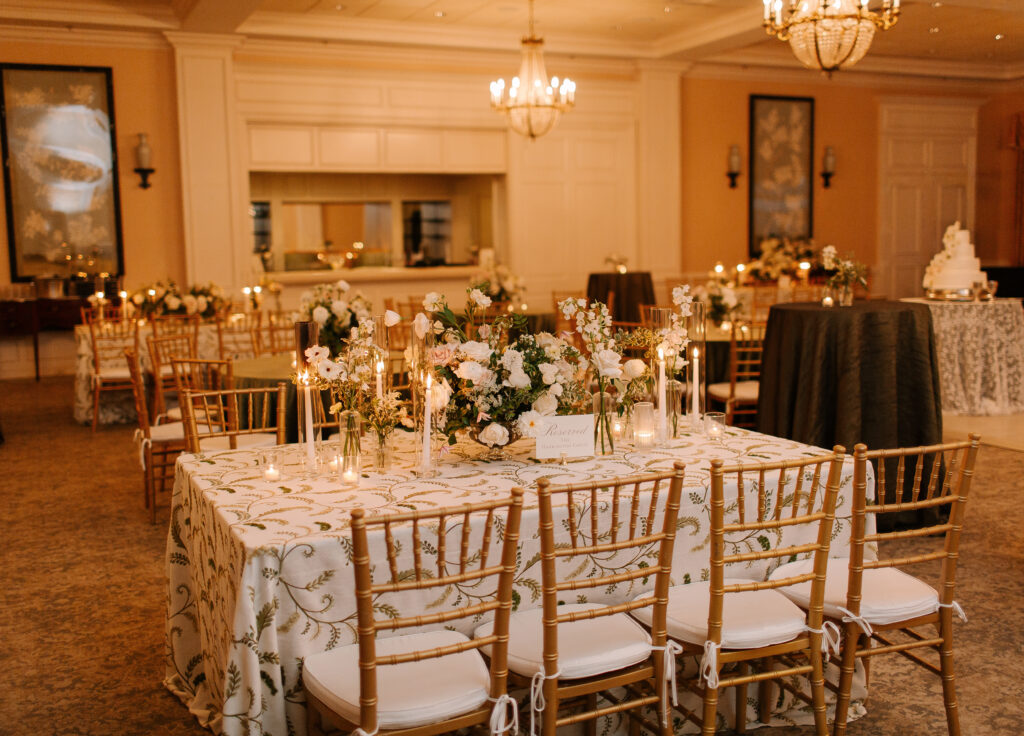 Lush and elegant floral centerpieces for Nashville wedding at Hillwood Country Club. Light pinks, blush and white florals consist of dahlias, garden roses, playa blancas, quicksand roses, ranunculus, lisianthus, majolikas, pieris, delphinium, sweet peas, saponaria, clematis, astilbe, and contrasting greenery. Centerpieces were accompanied by warm candlelight and lush vines growing near the bar for a beautiful wedding reception. Design by Rosemary and Finch Floral Design in Nashville, TN. 