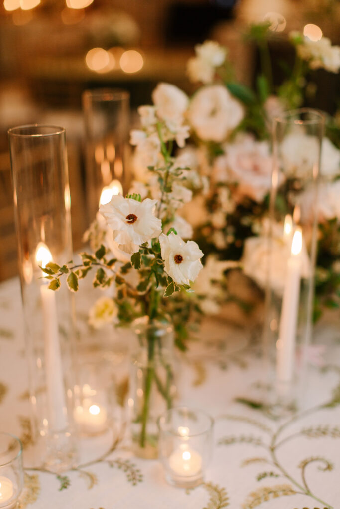 Simple, bright bud vases scattered throughout the room for a gorgeous wedding reception at Hillwood Country Club in Nashville. Bud vase florals highlighted dahlias, quicksand roses, astilbe, pieris, lisianthus, ranunculus, butterfly ranunculus, sweet peas, clematis, delphinium, saponaria and light greenery to reflect an elegant atmosphere. Design by Rosemary and Finch Floral Design in Nashville, TN.