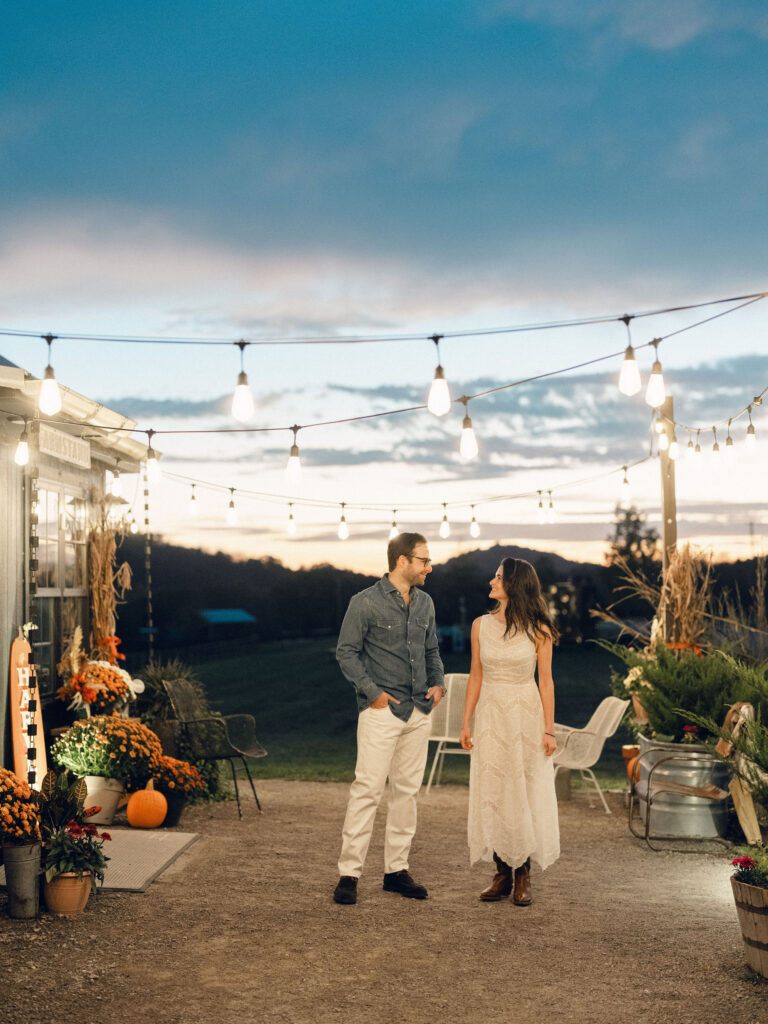 Simple, meadow-like arrangements are scattered on the tables for a southern themed welcome party at Southall Farm and Inn. The florals resemble bunches of wildflowers placed in glass jars and include cosmos, zinnias, cornflowers, yellow solidago riceflower and other wildflowers in an array of pinks, reds, yellows and oranges. Design by Rosemary and Finch Floral Design in Nashville, TN.
