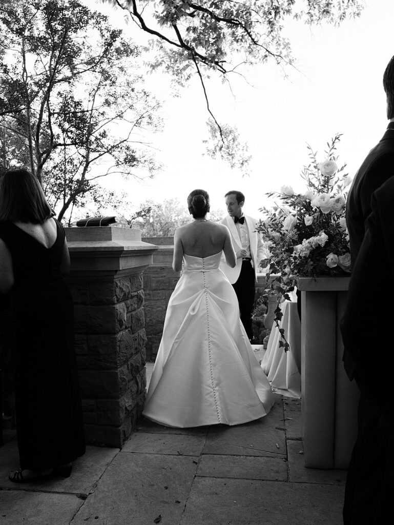 Simple and elegant floral arrangements for Cheekwood cocktail hour consisting of all-white bar arrangements and simple bud vases. Double tulips, hydrangeas, cloud and spray roses, delphinium, allium, riceflower, ranunculus, lisianthus, and white stock are used to create stunning floral moments scattered throughout the cocktail hour patio and bars. Design by Rosemary & Finch Floral Design in Nashville, TN.