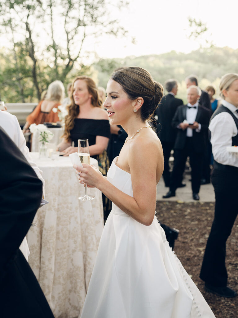 Simple and elegant floral arrangements for Cheekwood cocktail hour consisting of all-white bar arrangements and simple bud vases. Double tulips, hydrangeas, cloud and spray roses, delphinium, allium, riceflower, ranunculus, lisianthus, and white stock are used to create stunning floral moments scattered throughout the cocktail hour patio and bars. Design by Rosemary & Finch Floral Design in Nashville, TN.