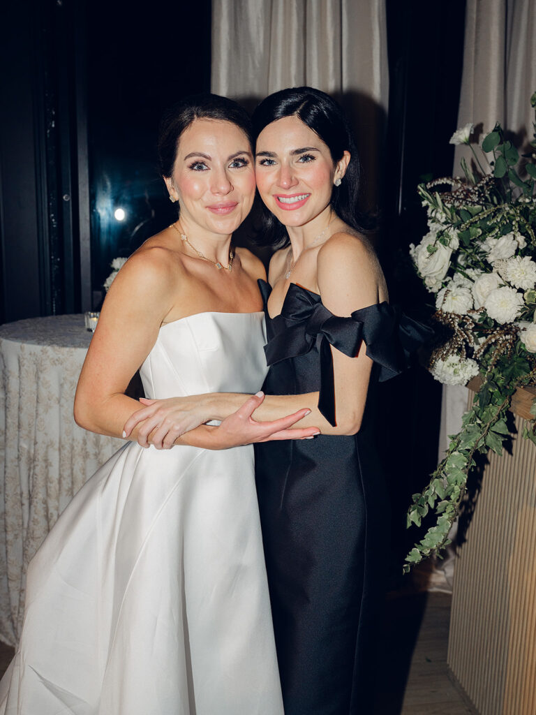 Romantic and stunning glass-tented wedding reception at Cheekwood botanical garden in Nashville, TN. Elegant garden-inspired centerpieces feature lush, all-white cloud roses, hydrangeas, lisianthus, dahlias, sweet peas, double tulips, delphinium, stock, allium, flowering champagne, and more with light greenery. Matching banquette meadows line either side of the glass tent creating a lush and timeless feel. Design by Rosemary & Finch Floral Design in Nashville, TN.