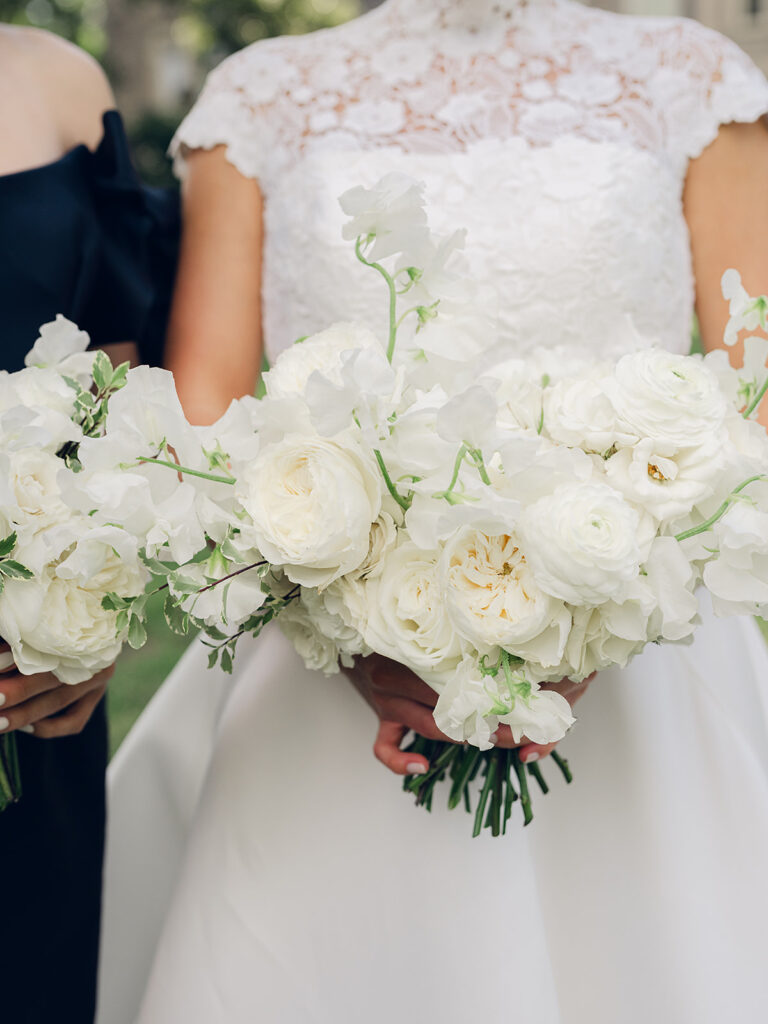 Romantic, editorial bridal bouquet featuring all-white garden roses, cloud roses, sweet peas, spray roses, ranunculus, and lisianthus accompanied by olive branches and light greenery. Soft and romantic bouquet to highlight elegance of a botanical tented wedding at Cheekwood. Design by Rosemary & Finch Floral Design in Nashville, TN.