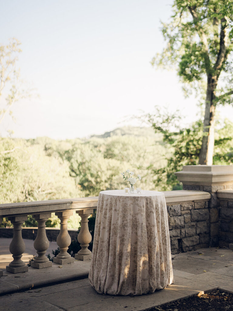 Simple and elegant floral arrangements for Cheekwood cocktail hour consisting of all-white bar arrangements and simple bud vases. Double tulips, hydrangeas, cloud and spray roses, delphinium, allium, riceflower, ranunculus, lisianthus, and white stock are used to create stunning floral moments scattered throughout the cocktail hour patio and bars. Design by Rosemary & Finch Floral Design in Nashville, TN.